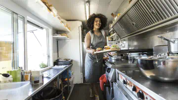 Food truck worker plates food