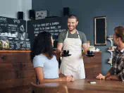 Barista serves two cappuccinos to guests 