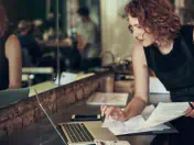 Woman takes notes and uses computer